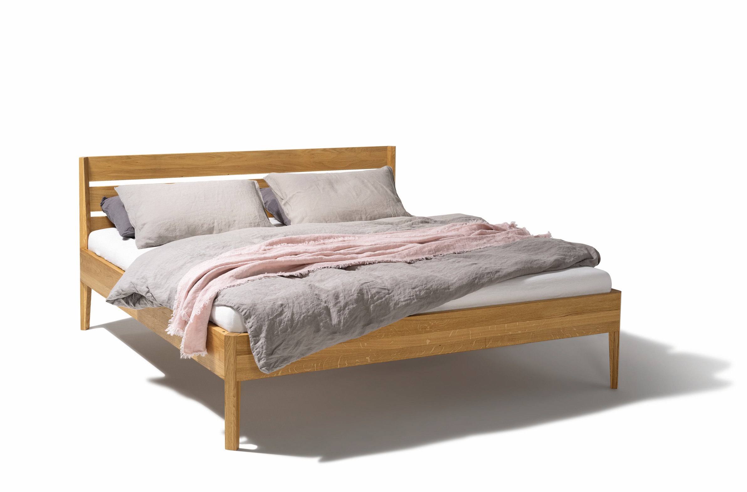 Holzbett Light von Team 7, Erle natur, mit grauer und rosa Bettwäsche, Frontansicht