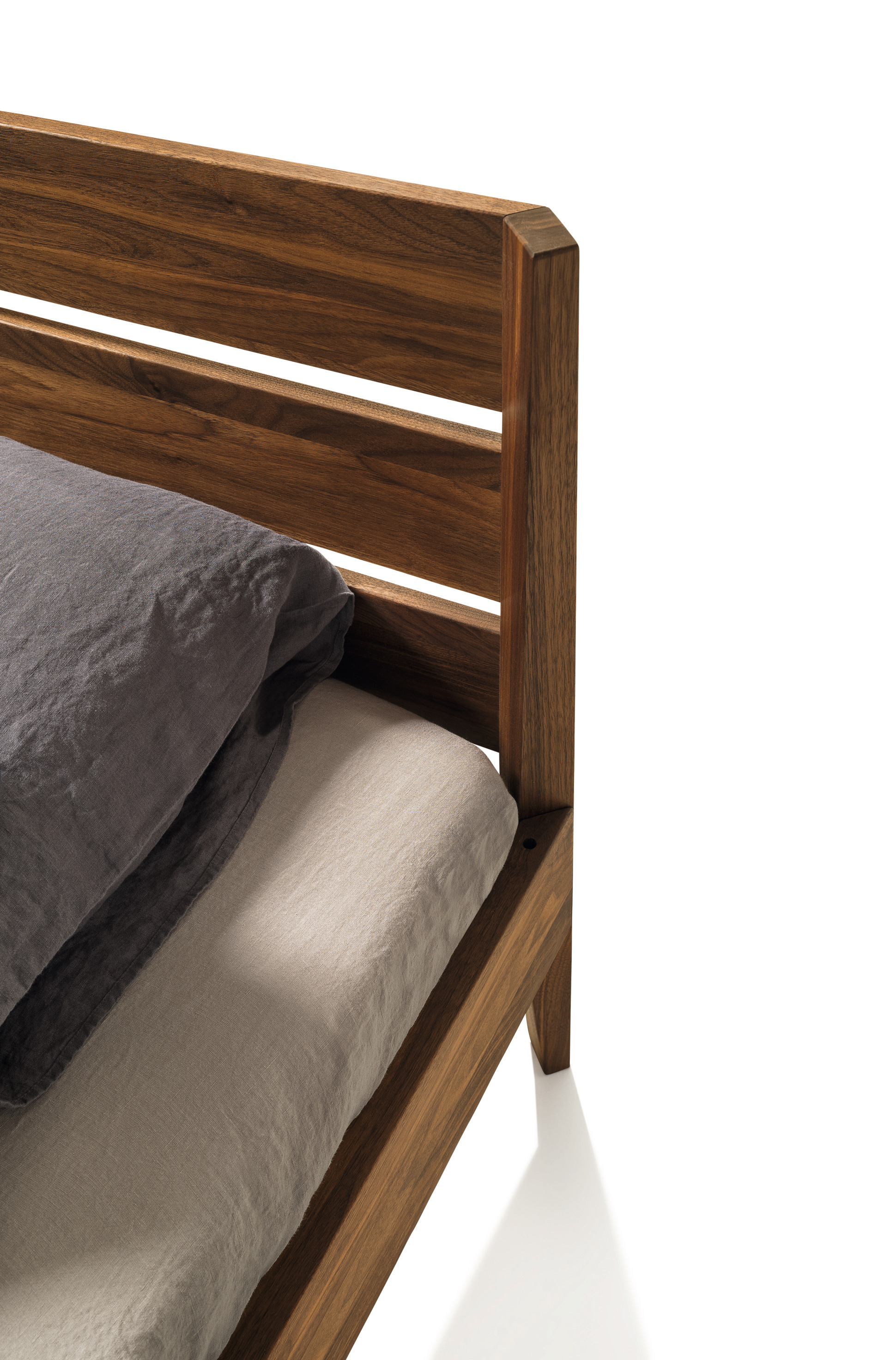 Light Bett von Team 7, Nussbaum massiv, mit Bettwäsche bezogen, Detailansicht des Kopfteils